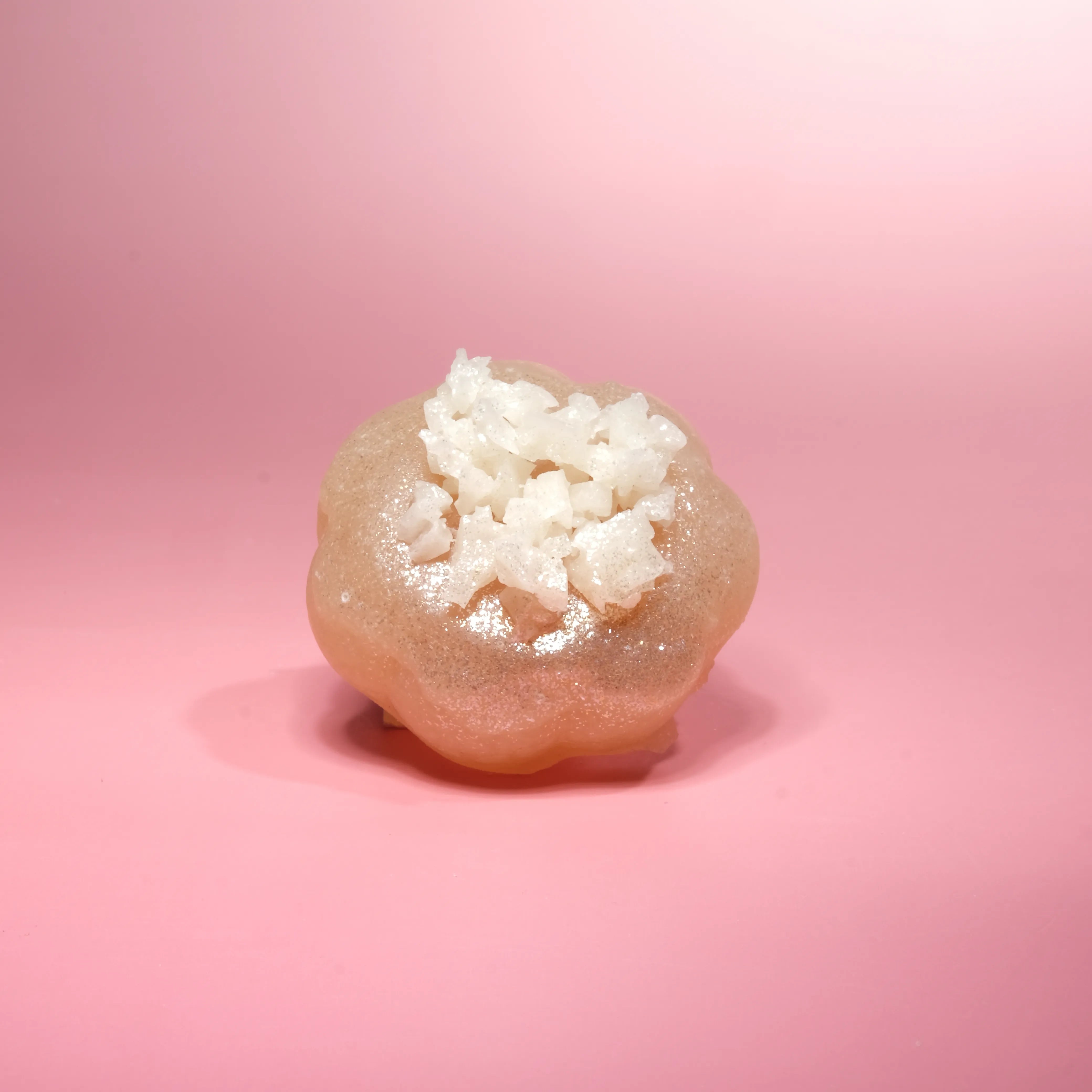 Creamy pastel crystal candy topped with white sugar crystals and subtle golden tones.