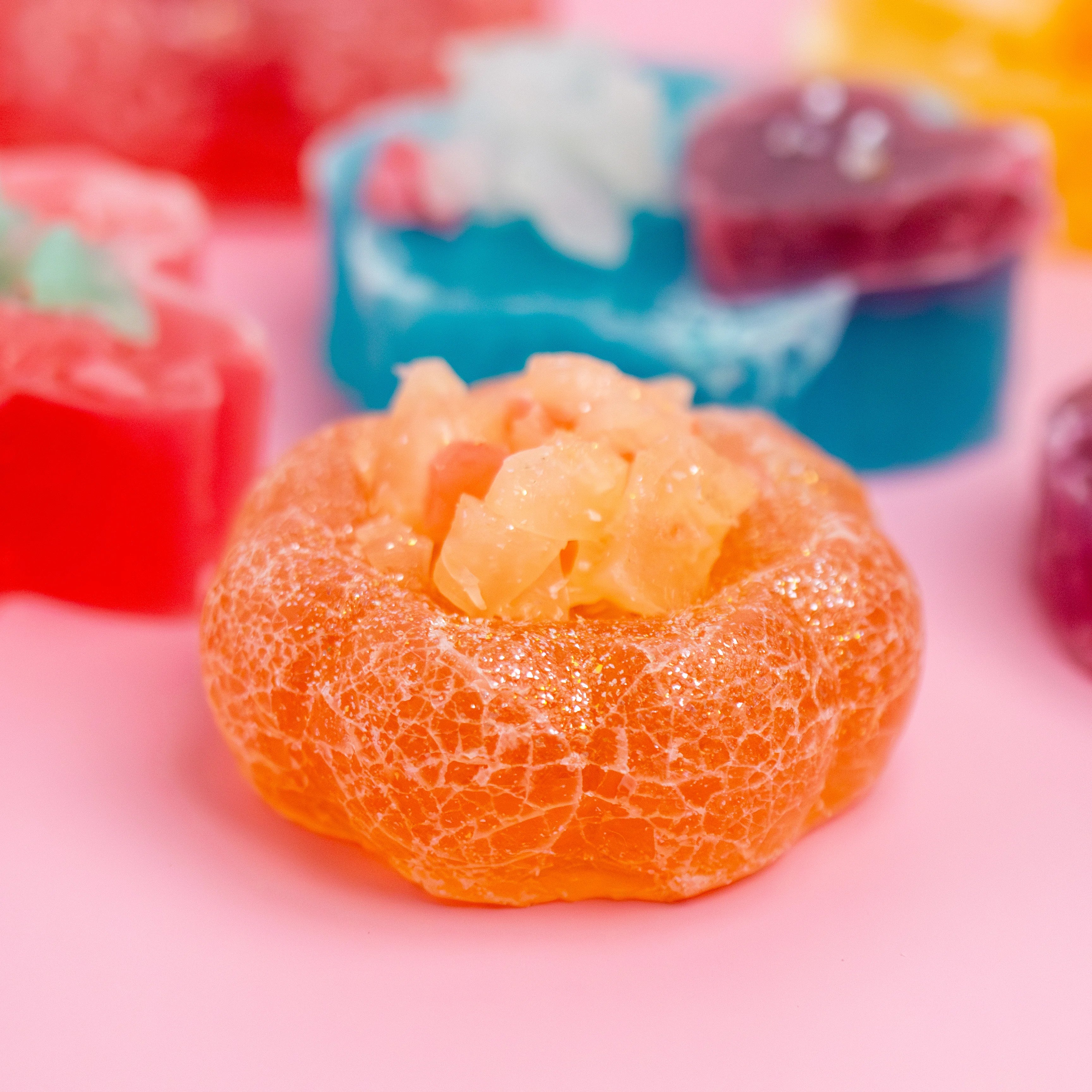 Close-up of a gummy candy with a textured surface on a pink background