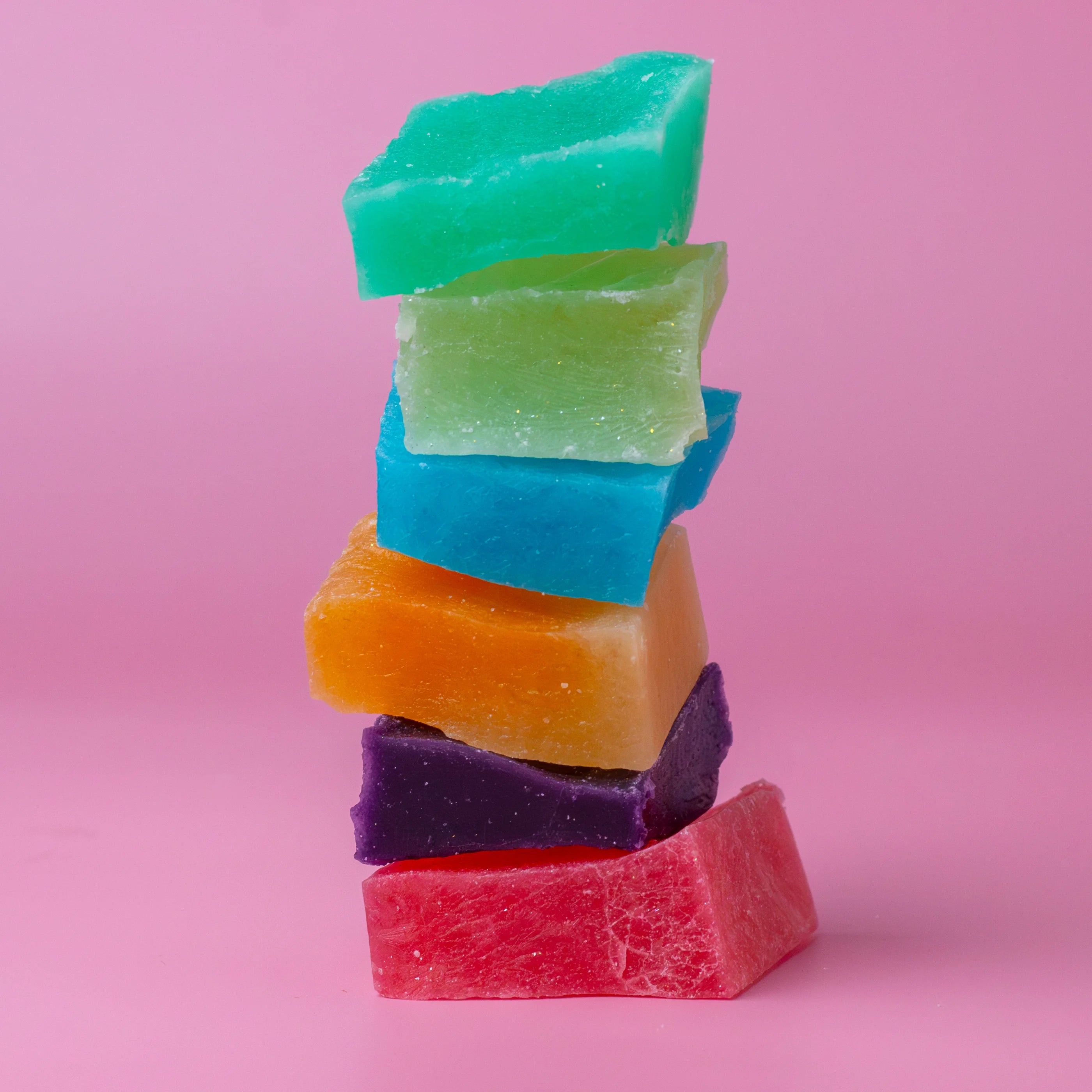 Stack of colorful gummy candy bars on a pink background