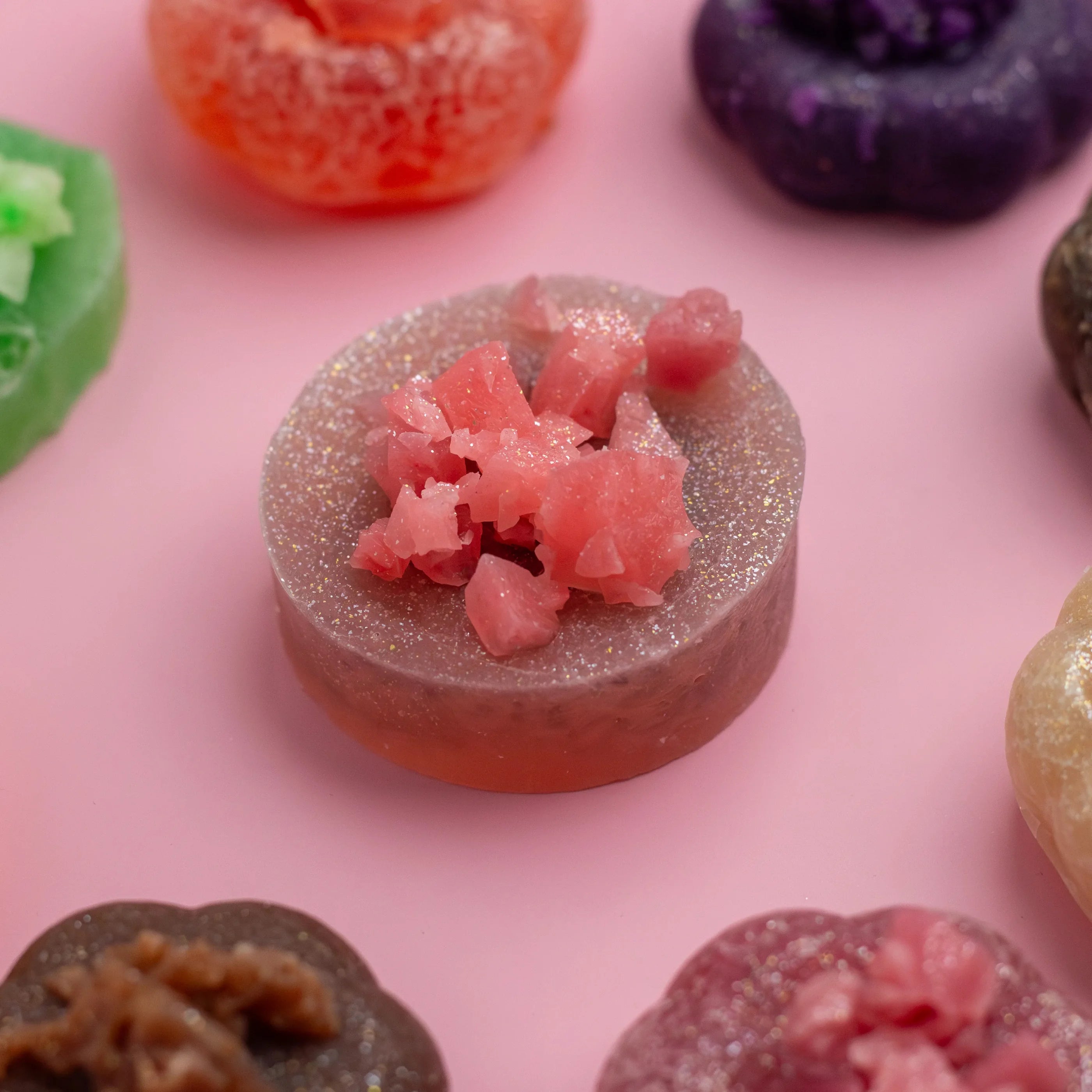 Close-up of colorful gummy candies on a pink background