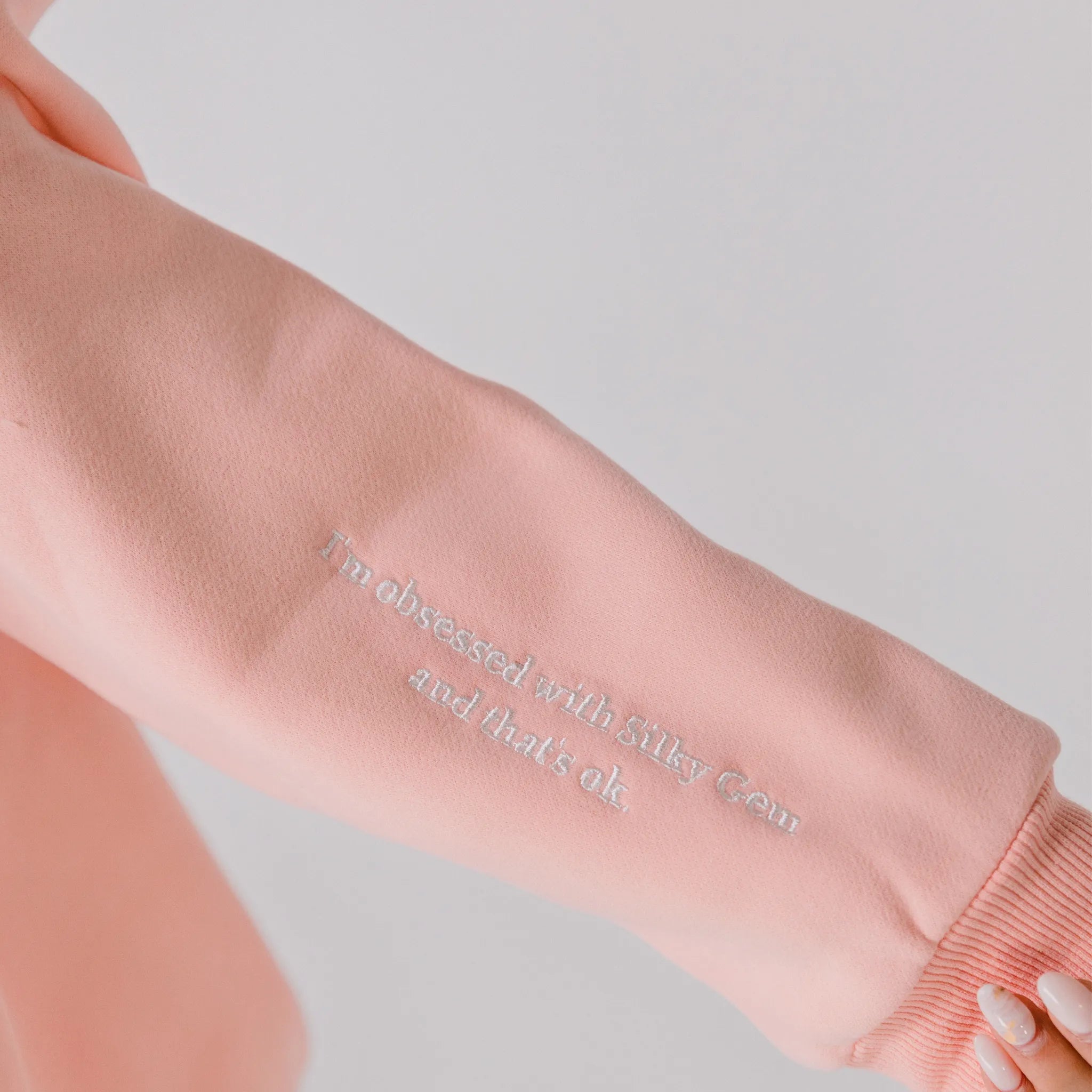 Pink sweatshirt with text on a plain background