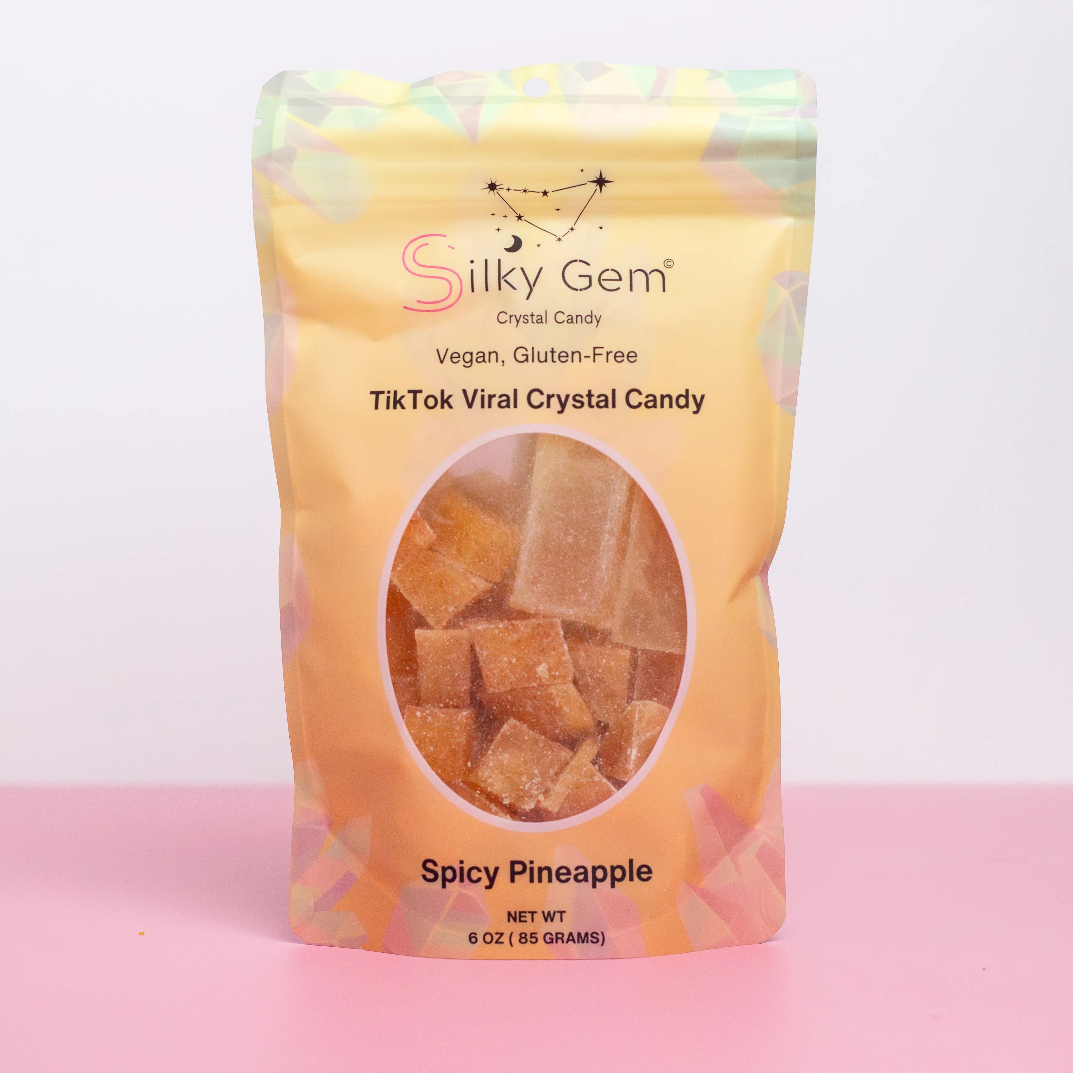 Silky Gem Spicy Pineapple crystal candy package on a pink background