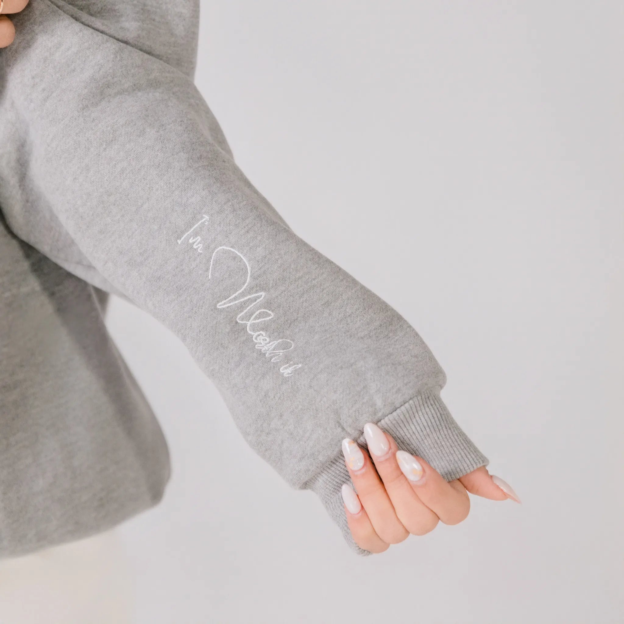 Gray sweatshirt sleeve with text on a plain background