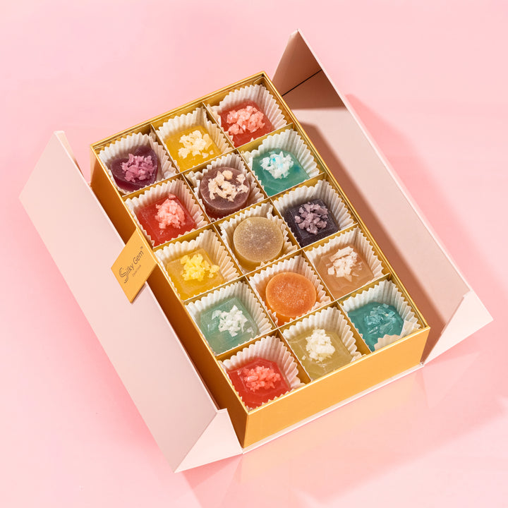 Silky Gem Gems Me Up 30-piece luxury crystal candy assortment in a gold box on a pink background