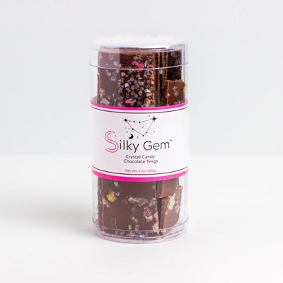 Silky Gem chocolate candy in a clear cylindrical container on a white background