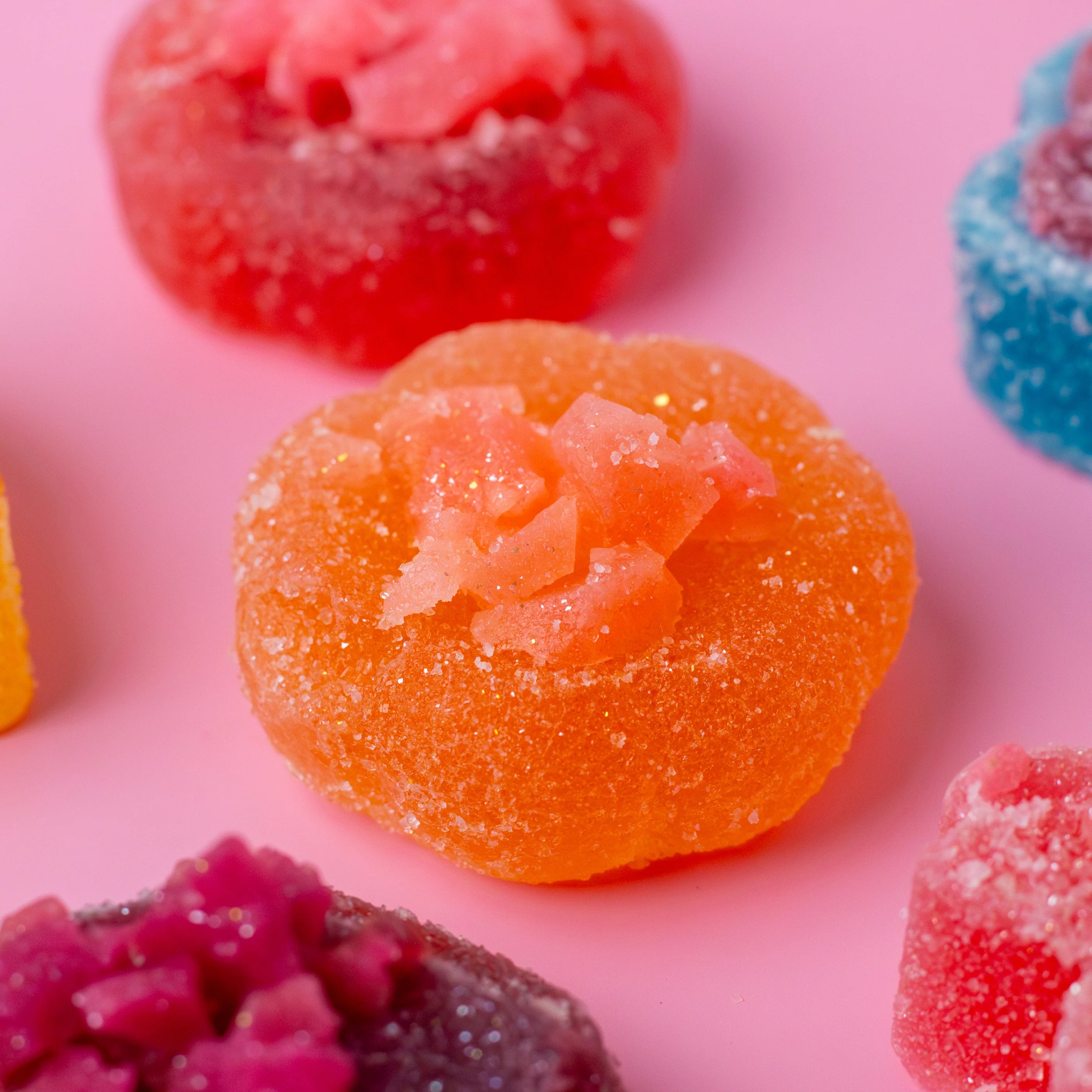 Colorful gummy candies on a pink background