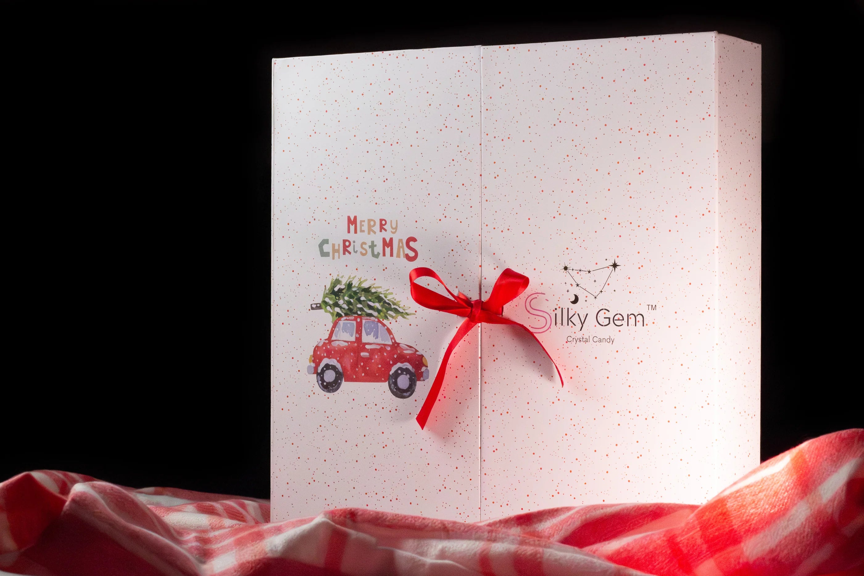 Silky Gem Christmas card with a red car and tree design on a white background.