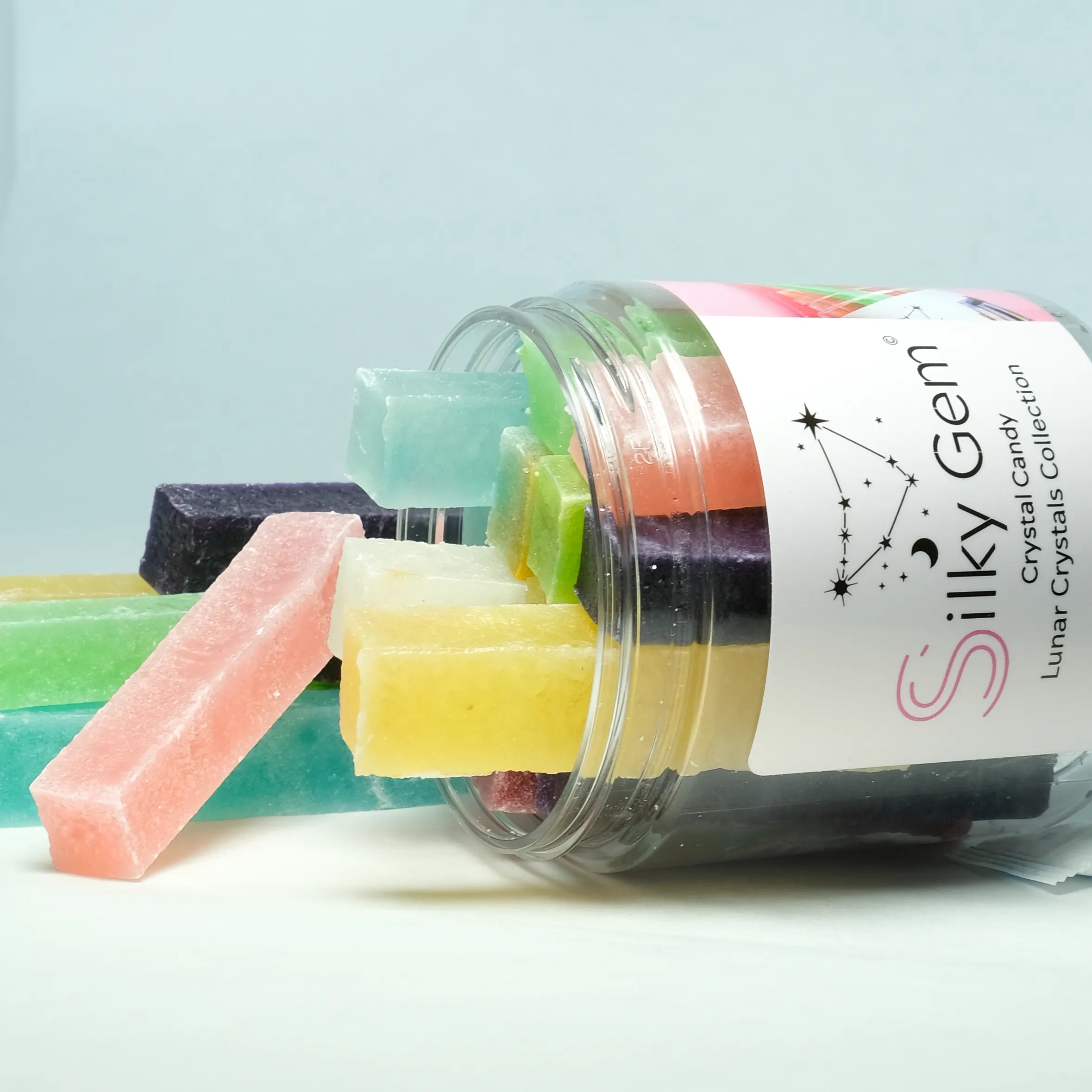 Silky Gem Lunar Crystals jar on its side with crystal candy bars spilling out, highlighting vibrant colors and the Lunar Crystals Collection label.