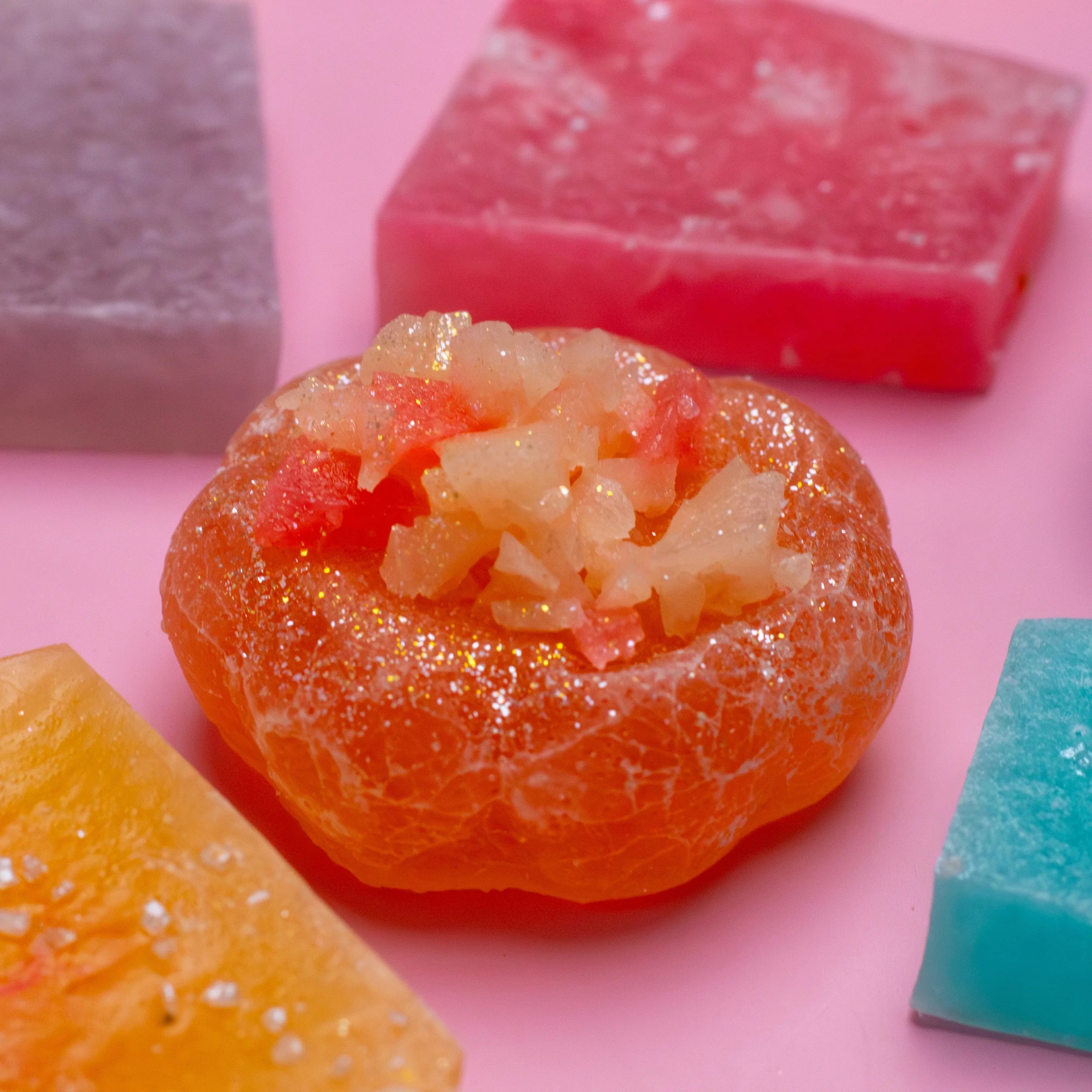 Close-up of colorful gummy candies on a pink background