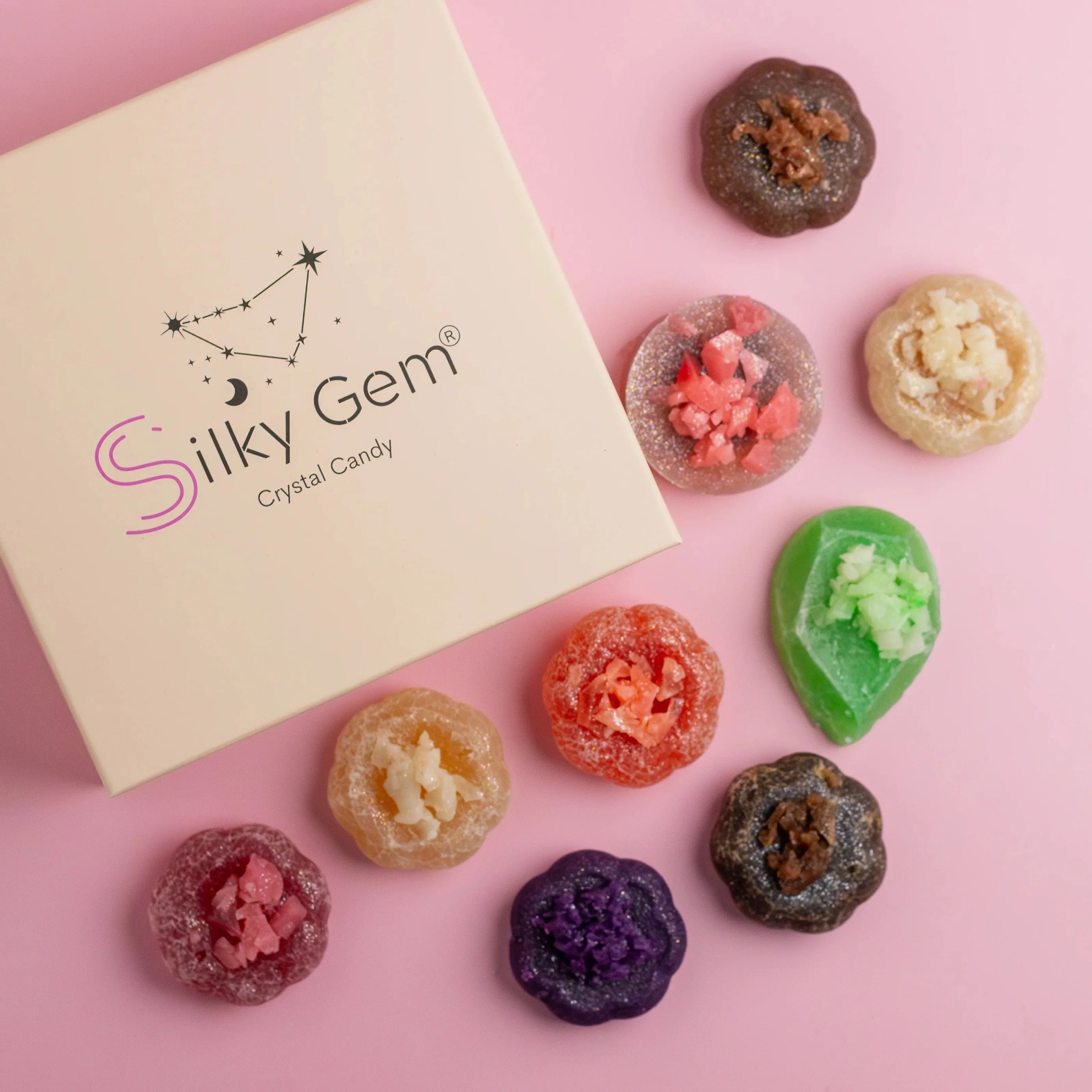 Silky Gem crystal candy on a pink background with a branded box.