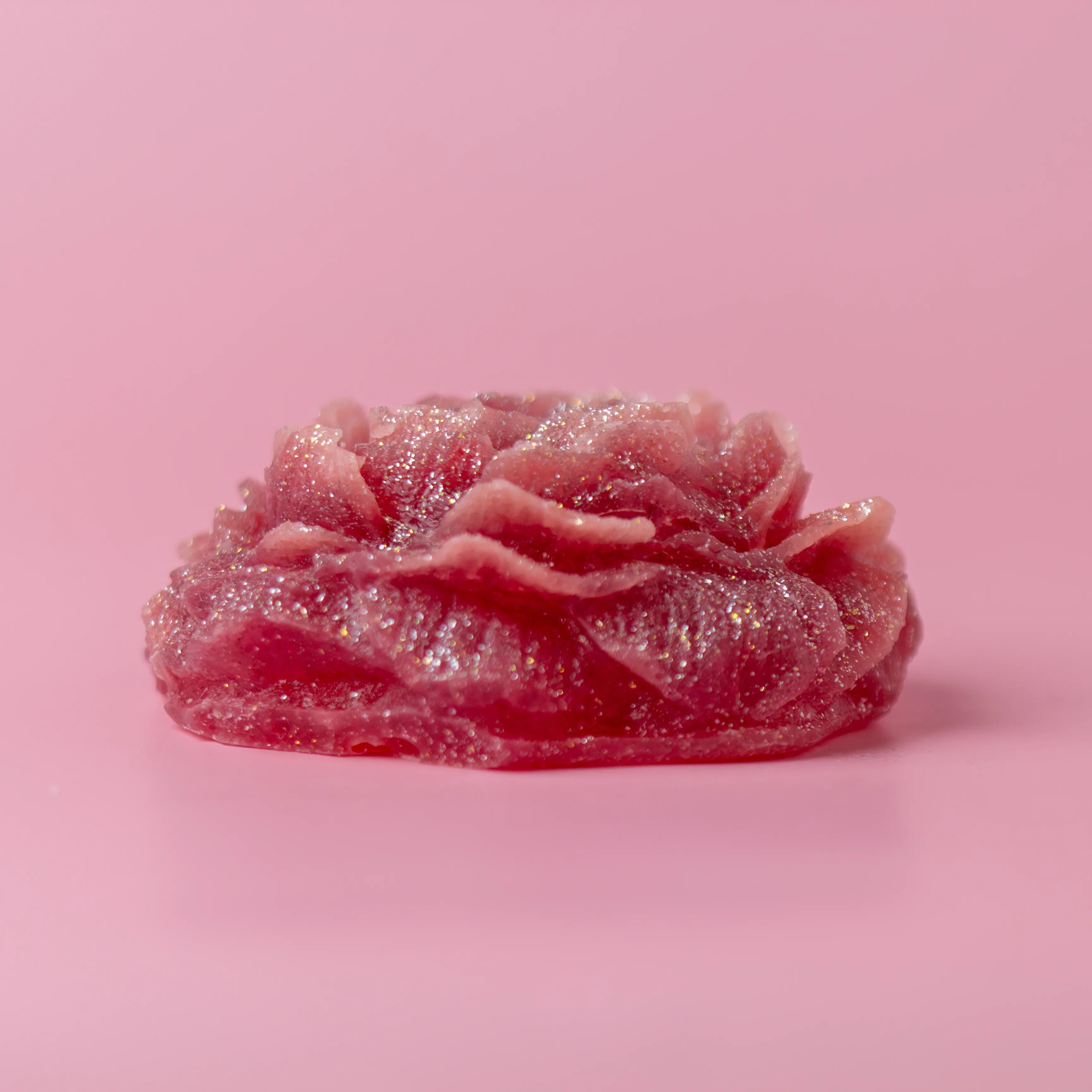 Pink flower-shaped soap on a pink background
