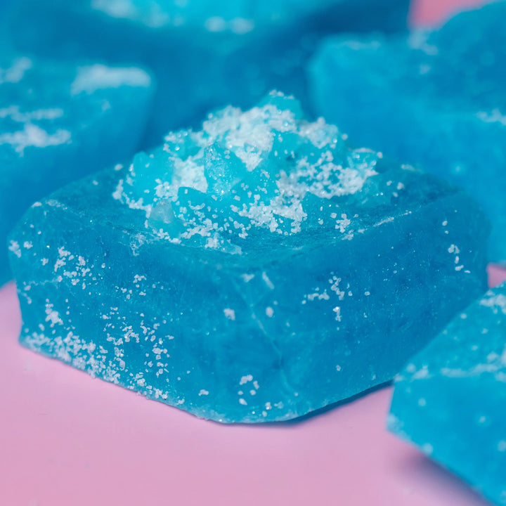 Blue soap bar with white specks on a pink background