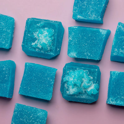 Close-up of Sour Blue Raspberry Lapis crystal candy on a pink background