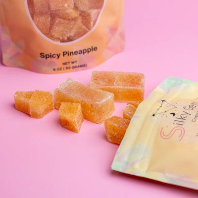Spicy Pineapple Bites crystal candy with Silky Gem pouch on pink background