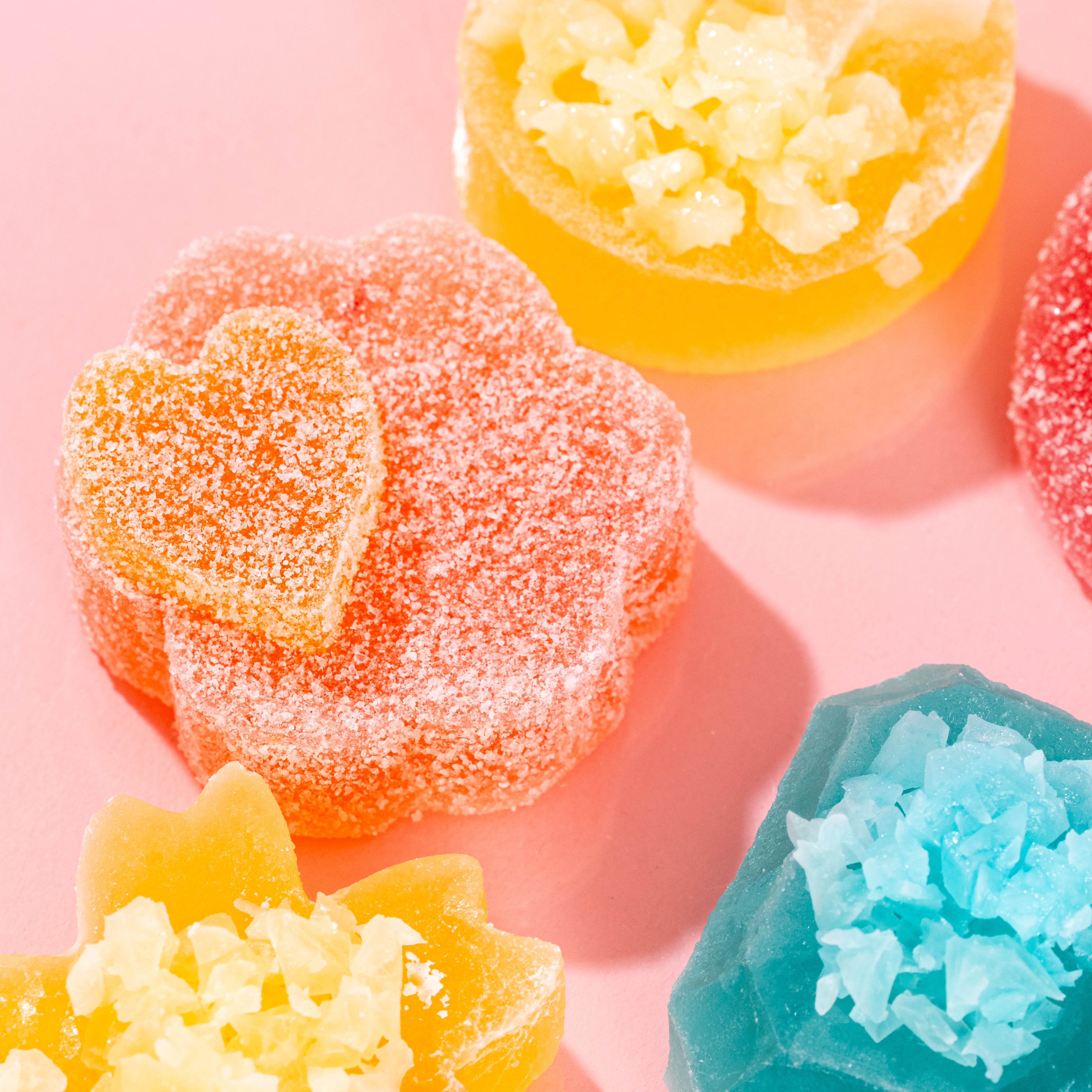 Colorful gummy candies on a pink background