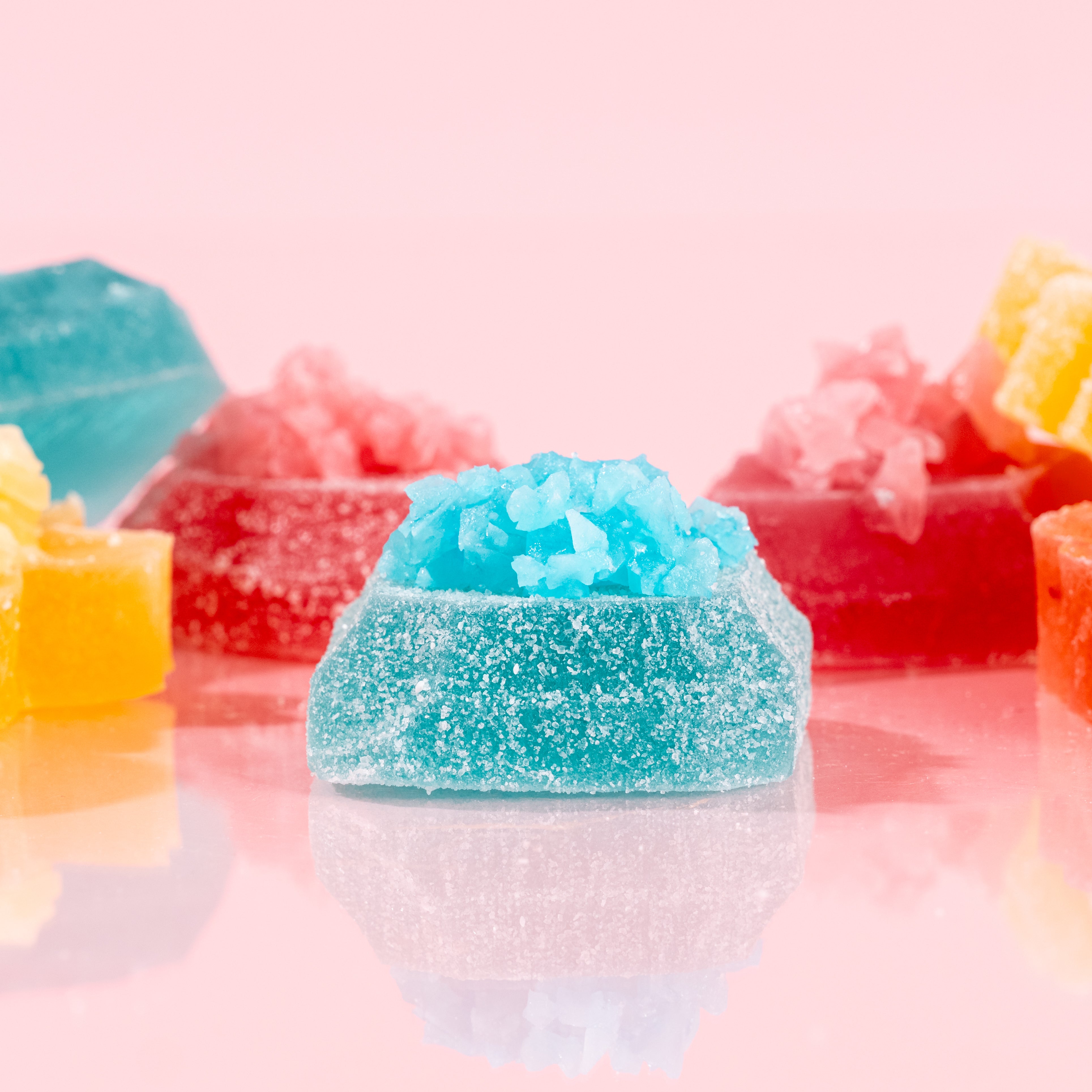 Colorful gummy candies on a pink background