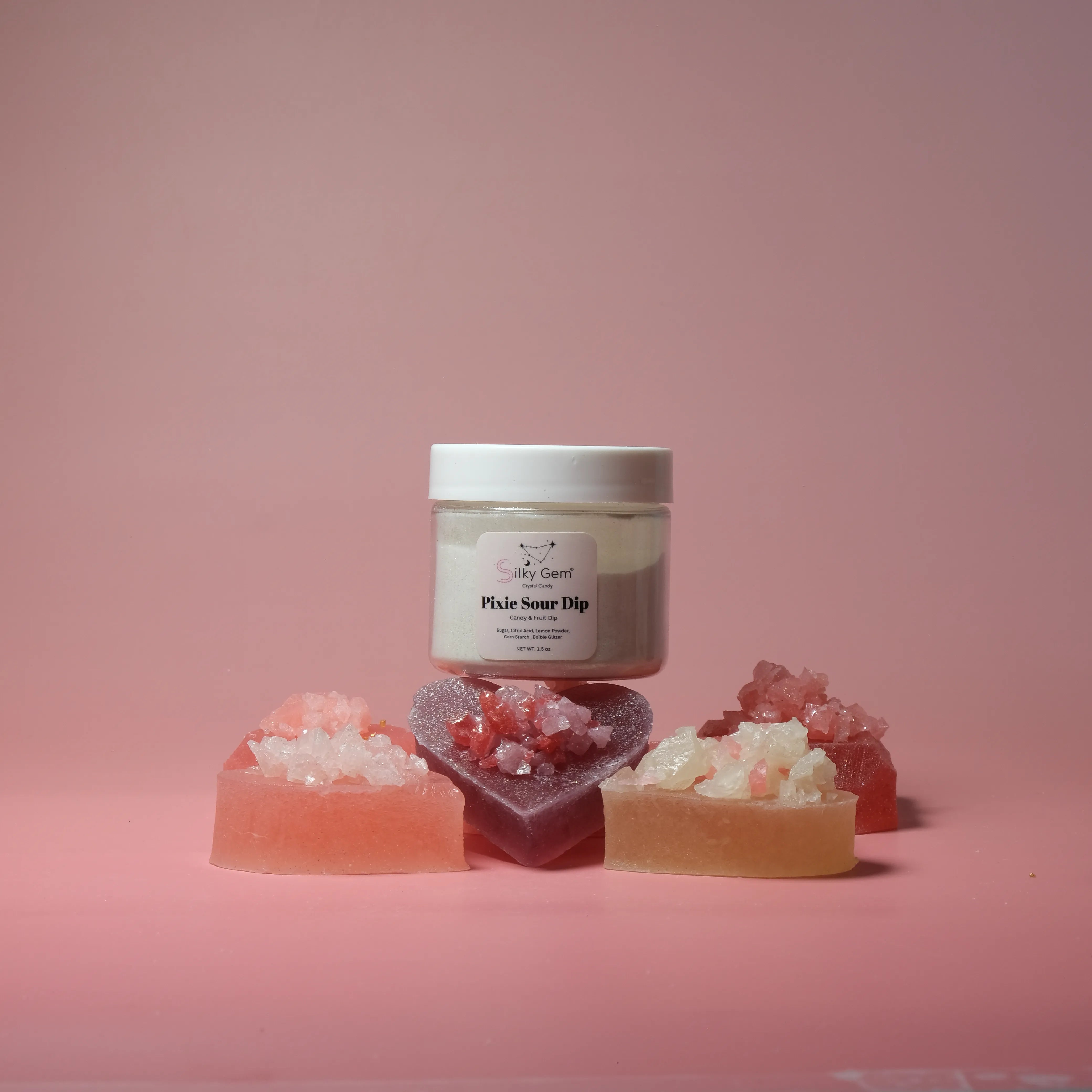 Jar of 'Fizzy Sour Dip' with colorful gummy candy on a pink background